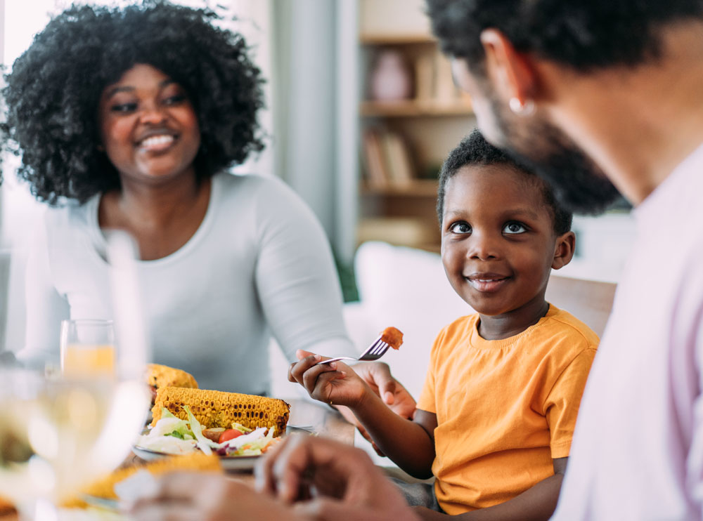 Young boy smiling at family dinner table